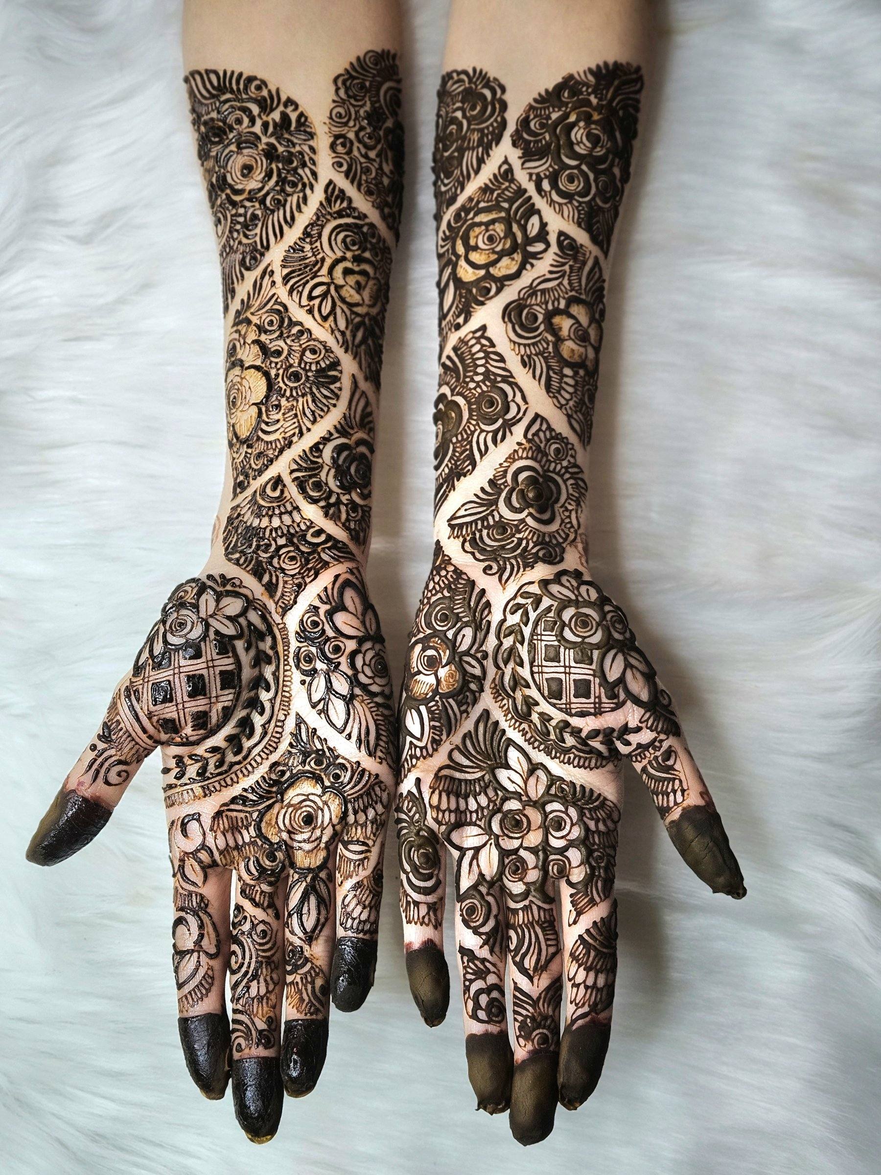 Shaded floral henna on hands and arms against white fur