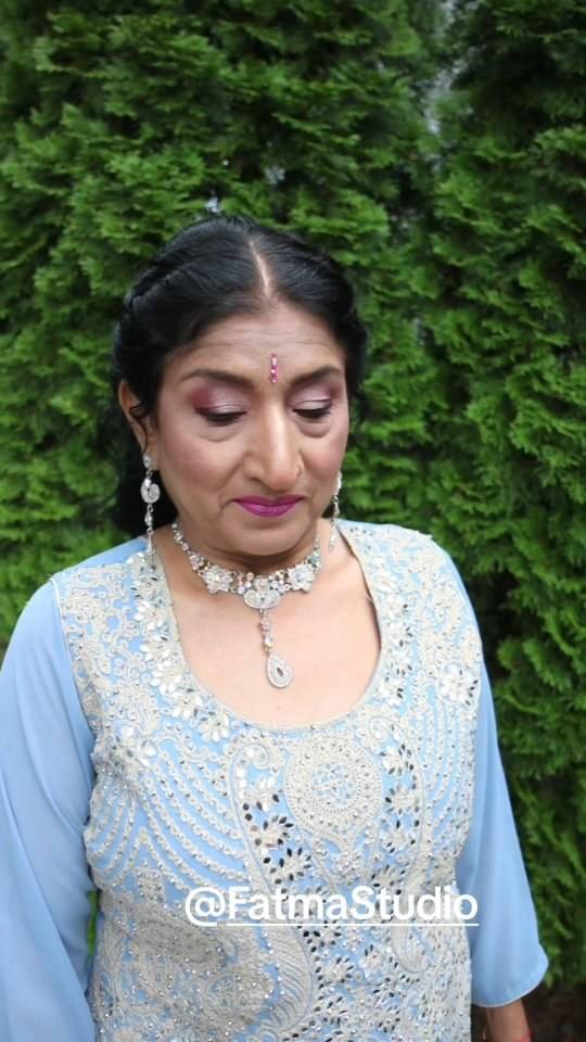Soft glam makeup with open curls and a silver choker on a pale blue outfit